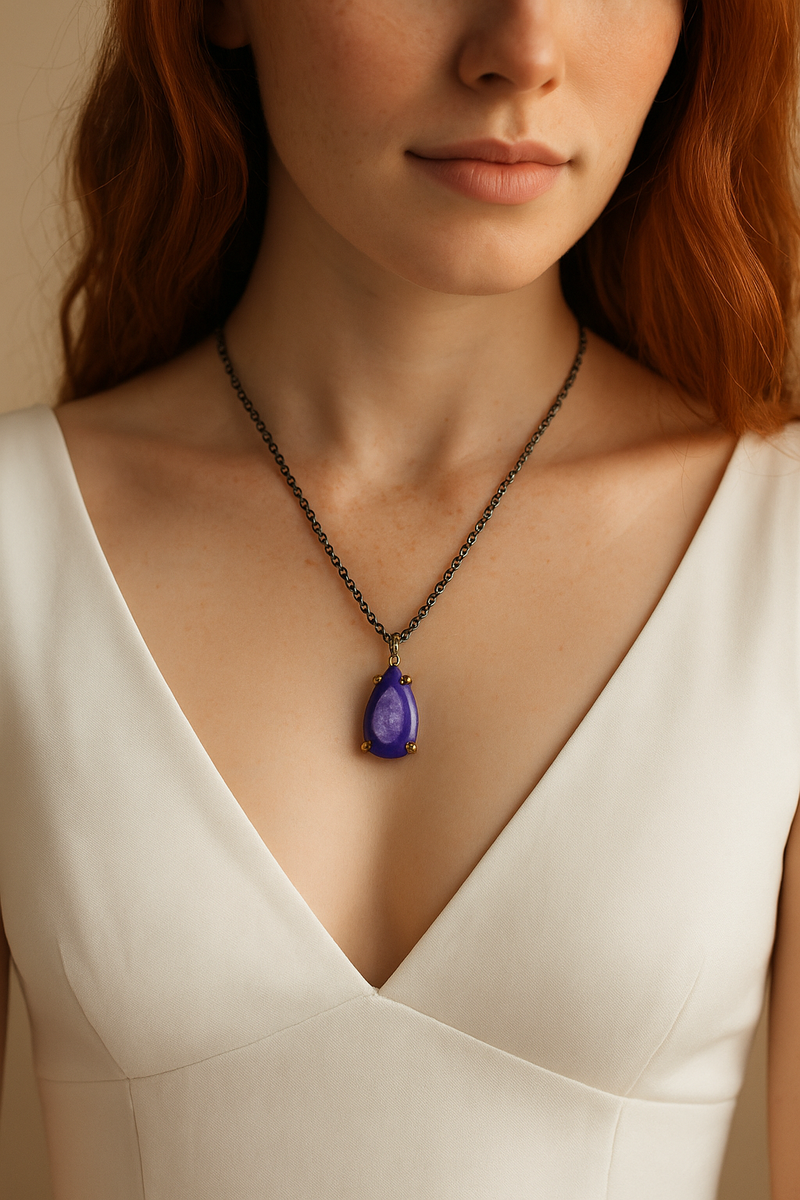 Woman wearing a necklace with a purple teardrop pendant